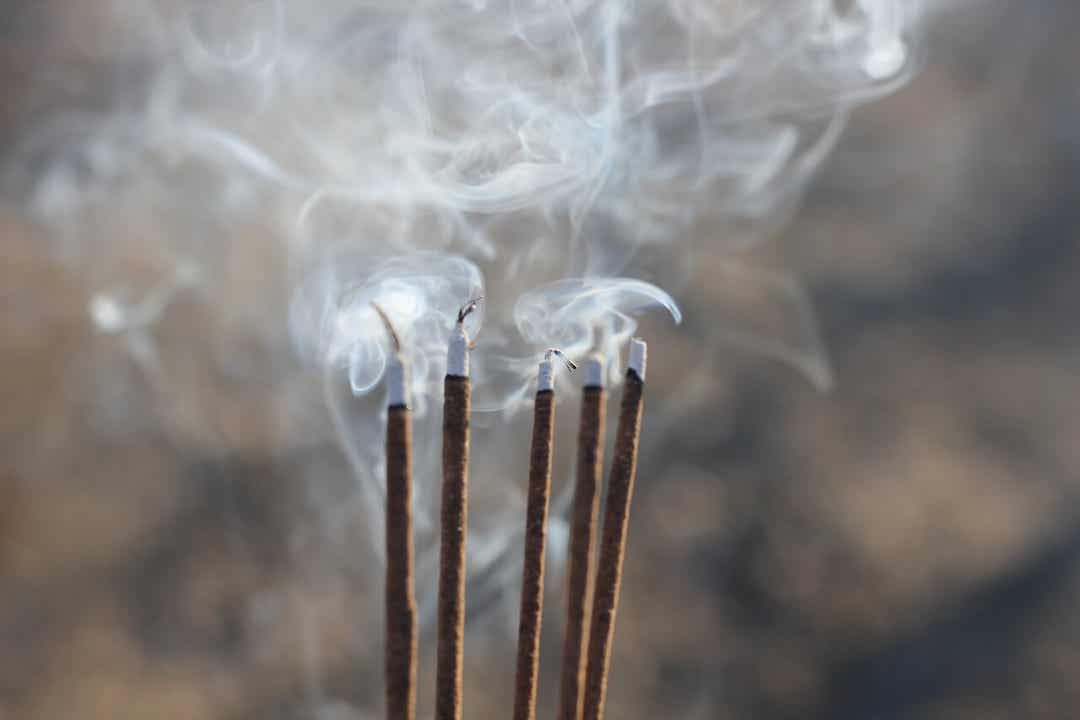 A row of burning incense sticks.