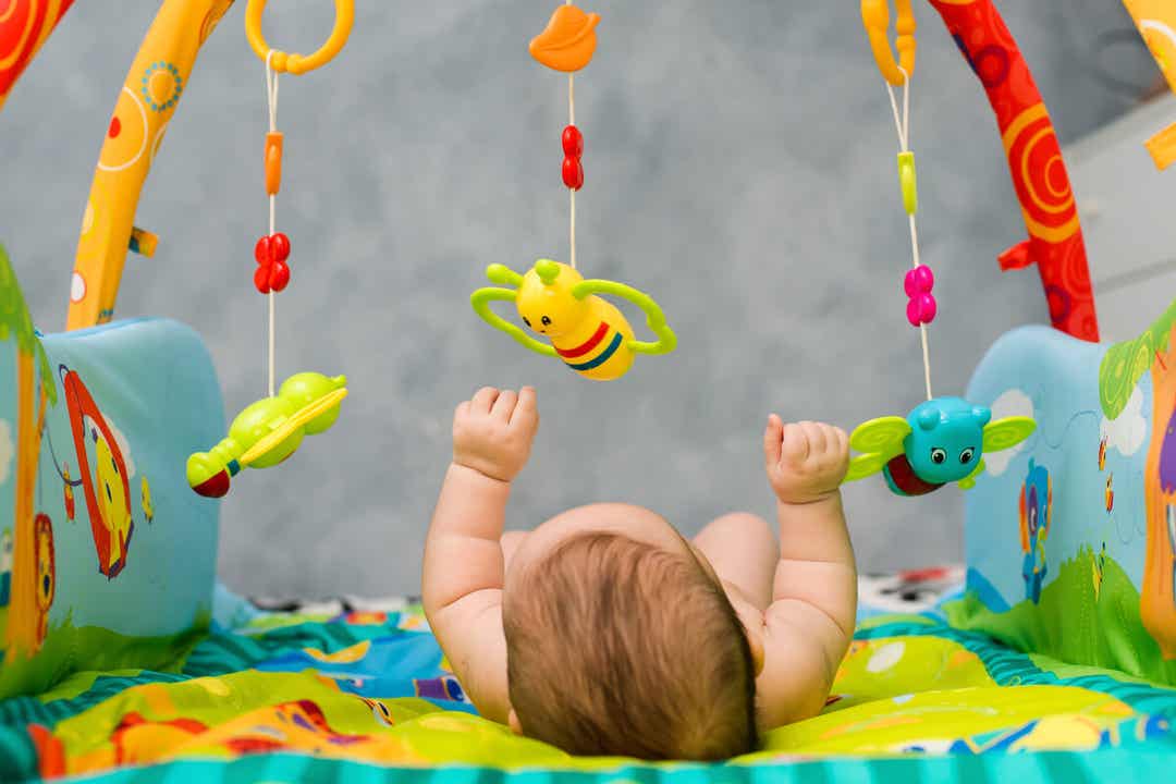赤ちゃんの体育館で遊んで仰向けに横たわっている子供。