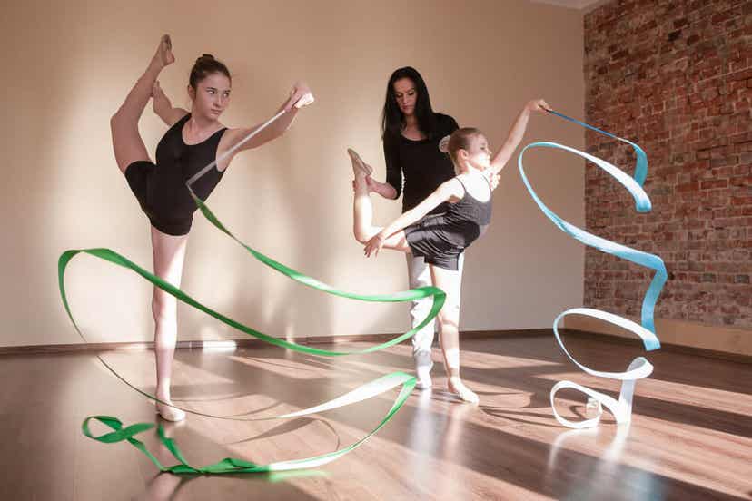 Zwei Mädchen praktizieren rhythmische Gymnastik.