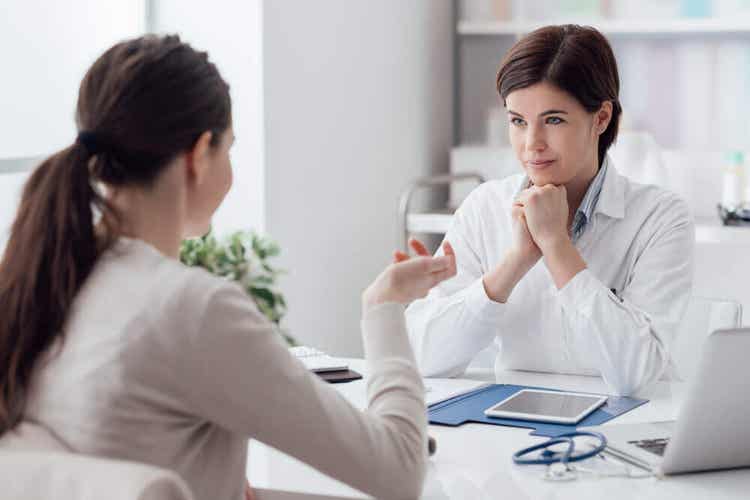 En læge, der taler med en patient om lupus