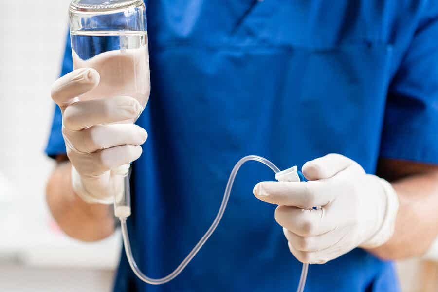 A doctor holding an IV container.