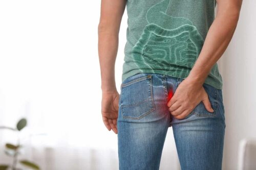 man wearing jeans with his back to the camera hands on his bottom in pain hemorrhoid, artist interpretation