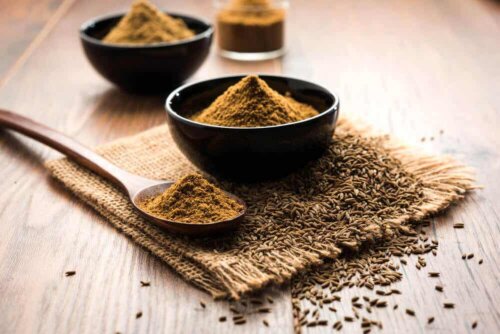 A bowl of cumin powder and seeds.