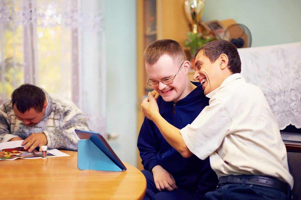 A man hugging a disabled person.