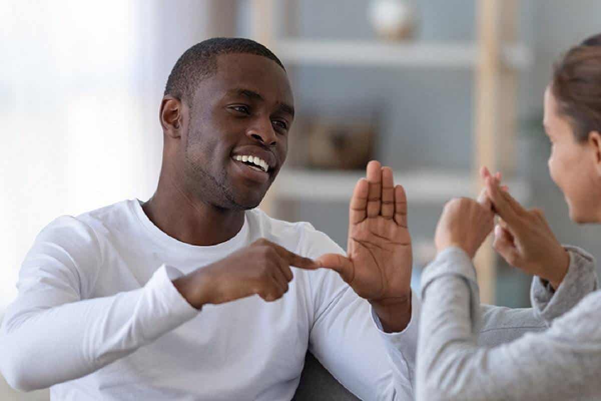 Ein Vater kommuniziert lächelnd mit seiner Tochter