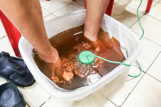 En person som bruker et detox fotbad.