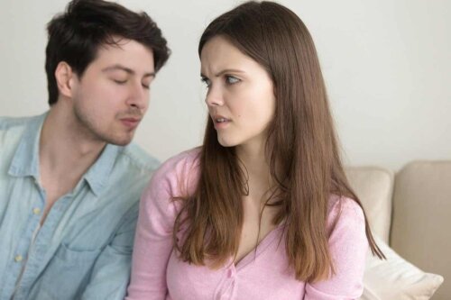 A woman rejecting a man's attempt to kiss her.