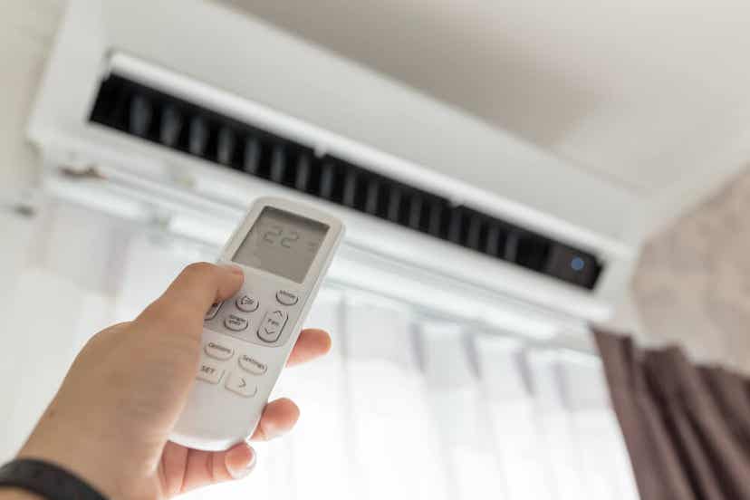 A person turning on their air conditioner.