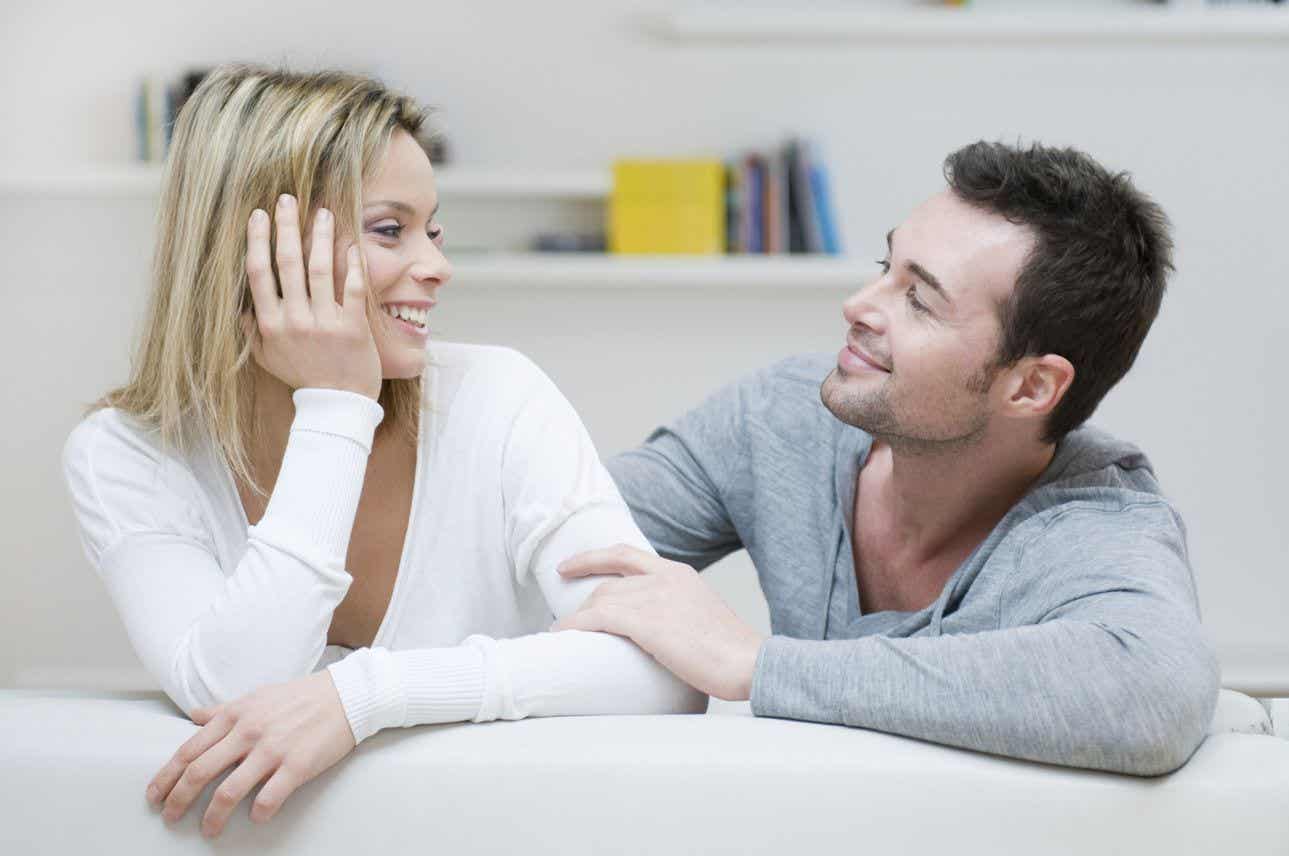 En mand og kone taler sammen i sofa