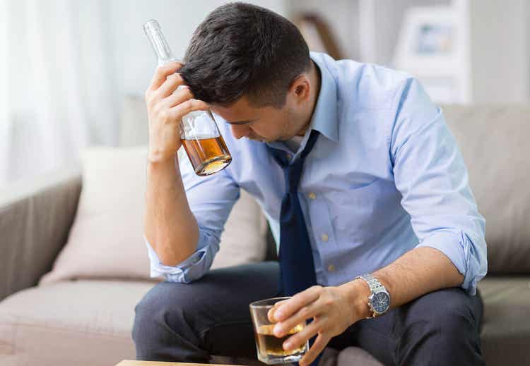 Zestresowana osoba pijąca alkohol.