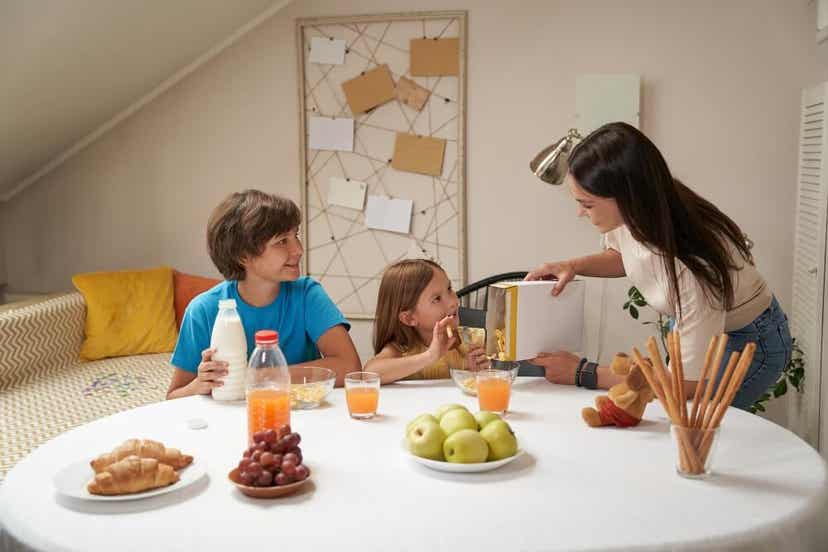 En mor som serverer frokost til sønnen og datteren.