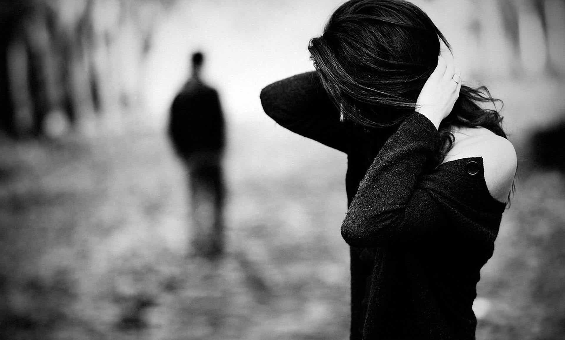 A black and white photo of a man walking away from a woman.