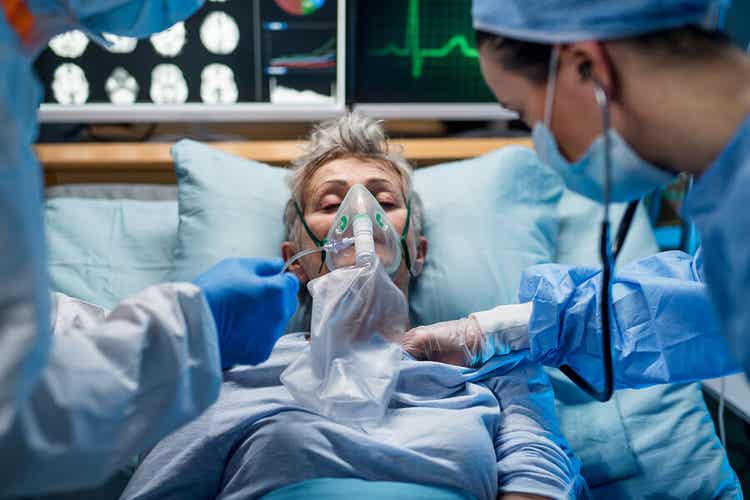 En eldre kvinne på et sykehus med en oksygenmaske over ansiktet.