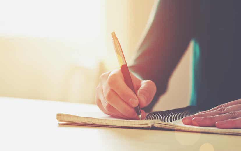 امرأة تكتب في دفتر ملاحظاتها.