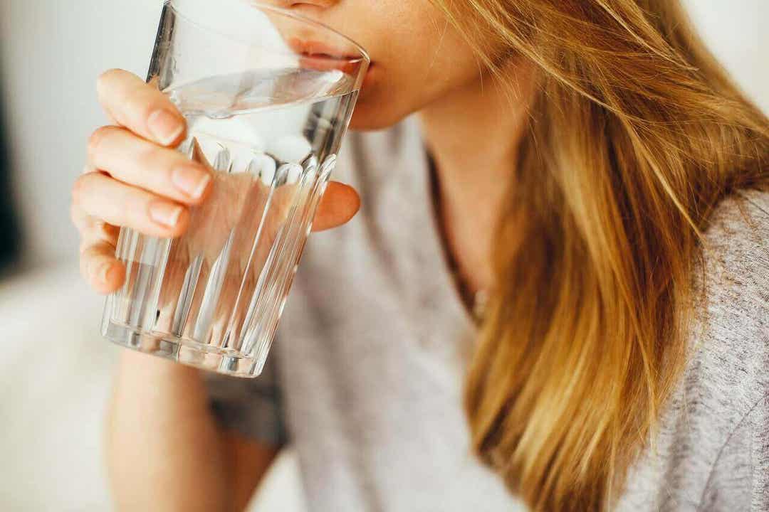 A woman drinking a glass of water.