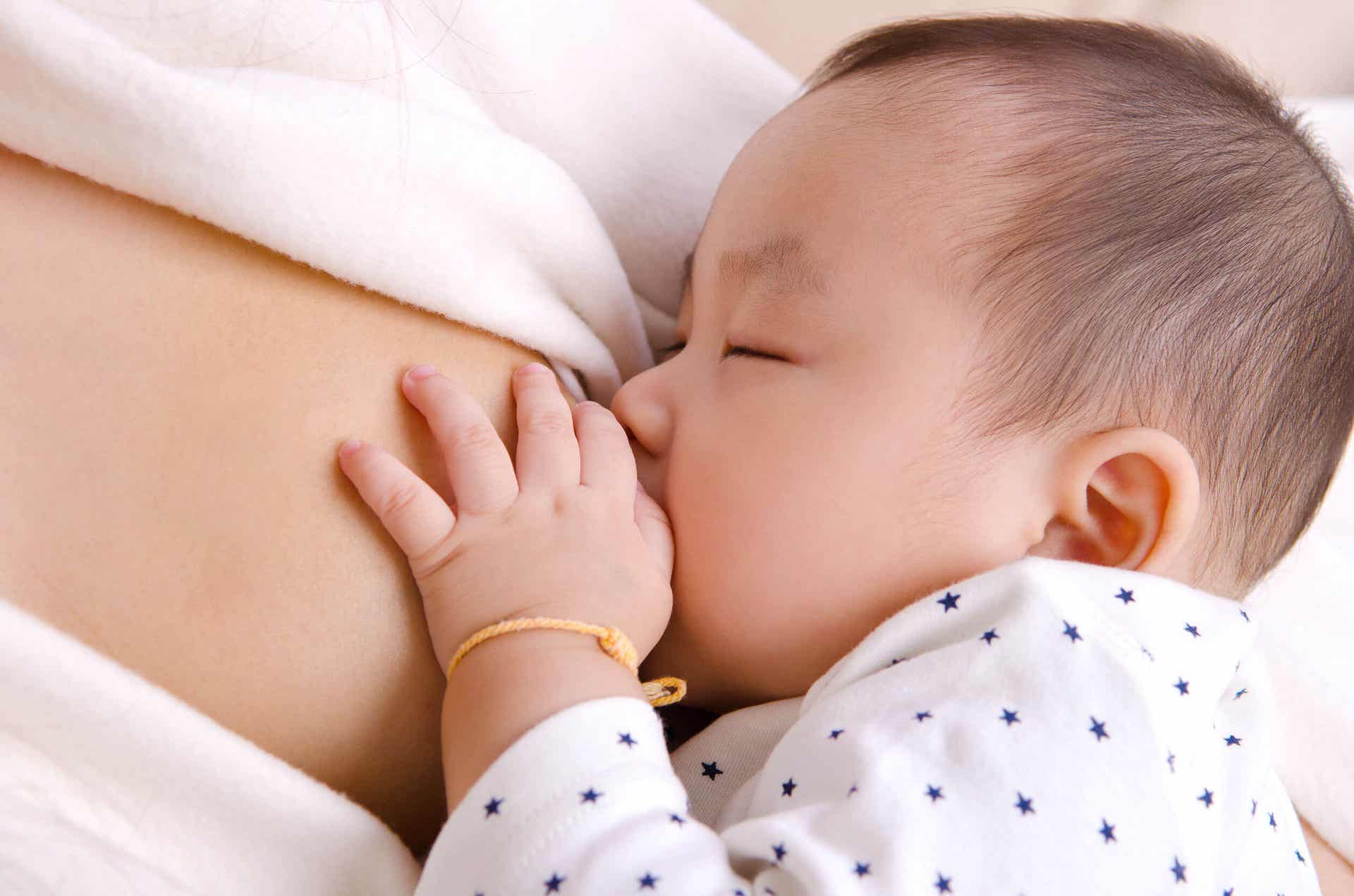 母親の胸で授乳している赤ちゃん。