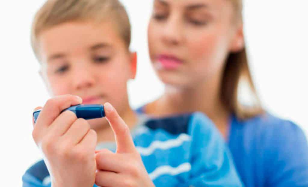 Bør barn spise sjokolade? En mor hjelper barnet sitt med å kontrollere insulinnivået.