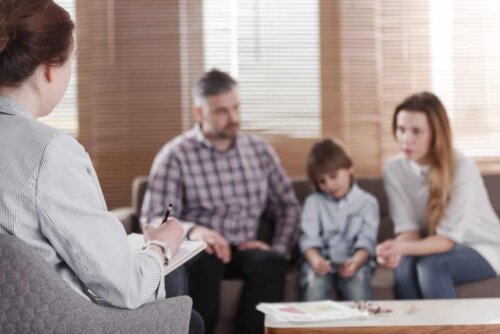 familieterapisession med en terapeut på et grått kontor