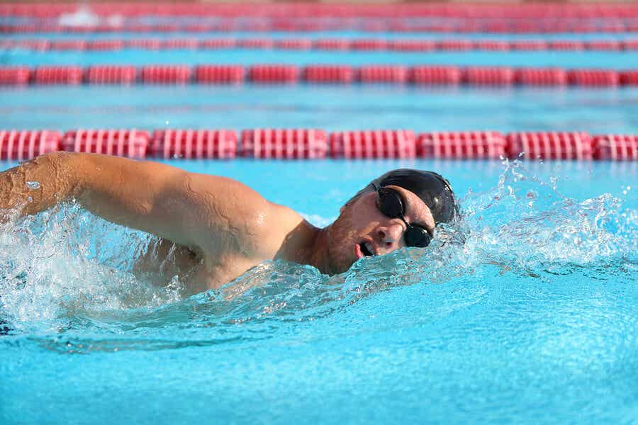 άνδρας που κολυμπά στην πισίνα με γυαλιά και σκουφάκι κολύμβησης