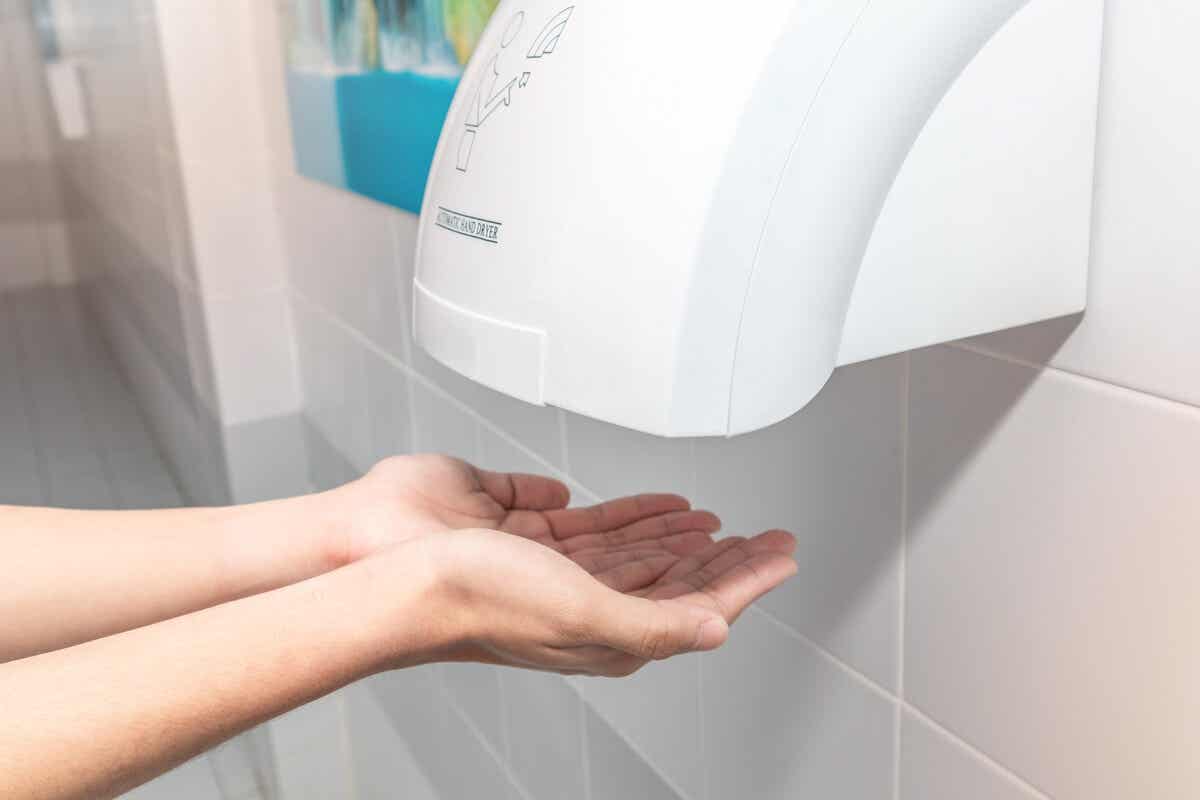 En kvinne tørker hendene med en tørketrommel.
