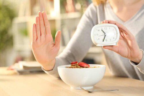 Kvinde med morgenmad og ur udøver intermitterende faste