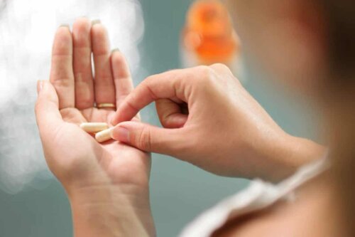 A person holding two pills.