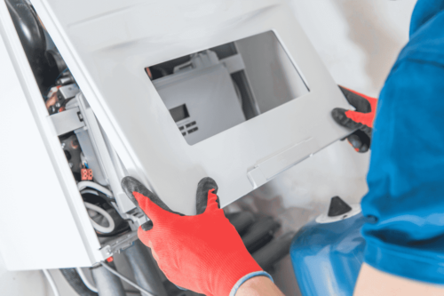 En person, der reparerer et apparat til varmesystem