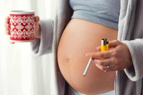 En gravid kvinne som røyker og drikker kaffe.