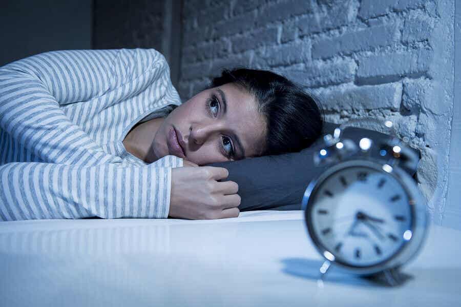 Søvnløs kvinde med forstyrret døgnrytme ligger i seng