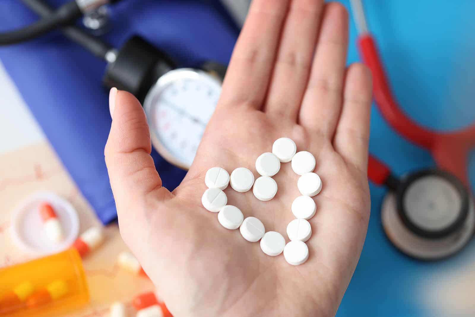 Dłoń z pigułkami ułożonymi w kształcie serca.