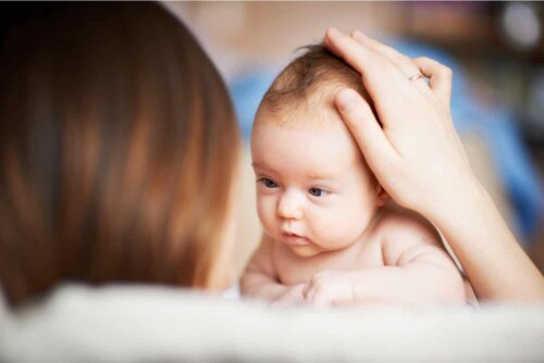 Mor holder sin babys hoved