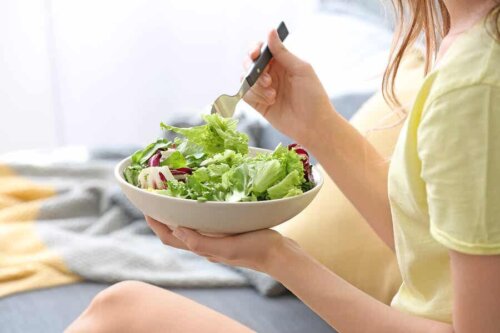 En kvinne som spiser en salat.