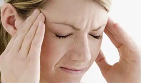 Kvinde oplever hovedpine på grund af vejrændringer